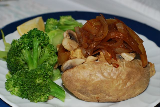 Caramelized Onions topping baked potato with tempeh and mushrooms, broccoli on the side