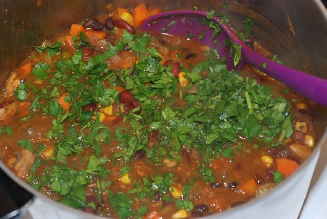 Cooked pot of chili with parsley added