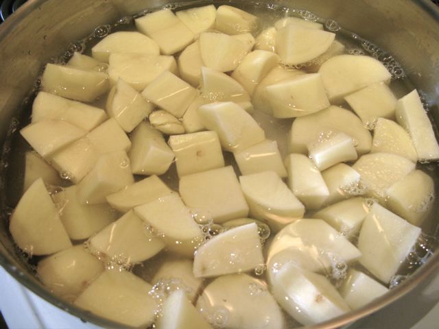 Potaotes and garlic being cooked in water