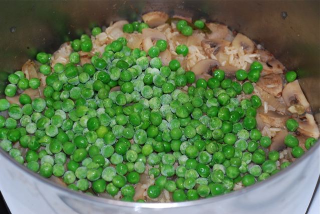 After 25 minutes add the peas to the top, recover with the lid, and cook for 5 more miutes