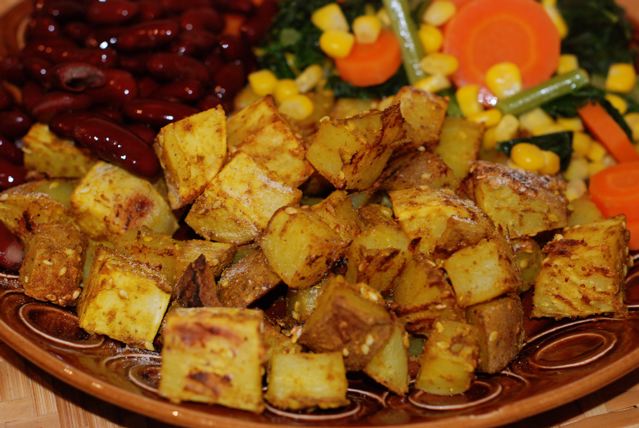 Curry Roasted Potatoes served with beans and braised carrots, corn and kale