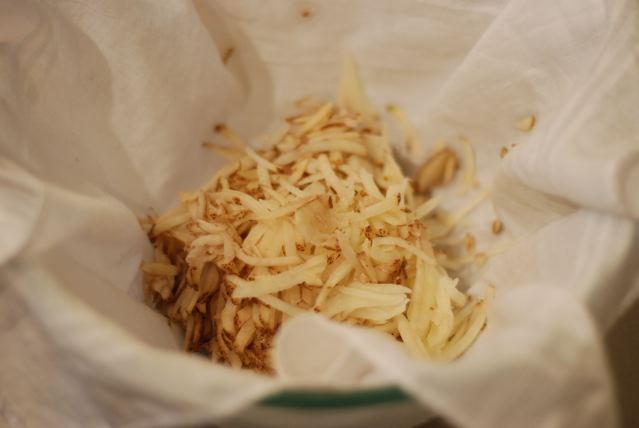 Add shredded potatoes to the cloth-lined bowl