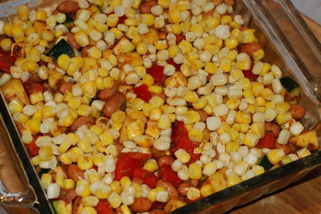 Beans and vegetable mix in a baking dish with a layer of corn