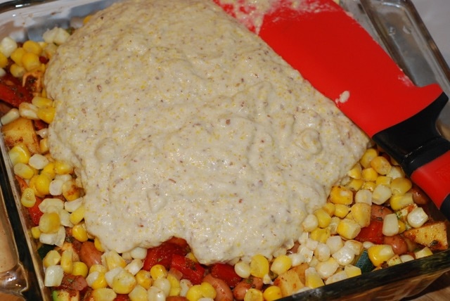 Spread the batter evenly over the corn layer in the baking dish