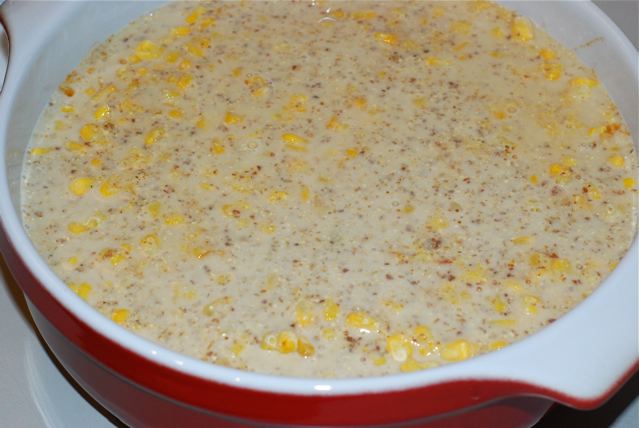 Casserole dish with the runny batter covering the frozen corn