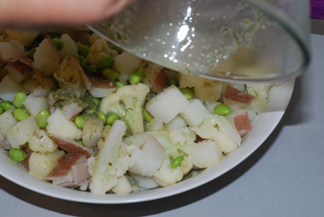 Pouring the dressing over the cooked potato, cauliflower and edamame 2