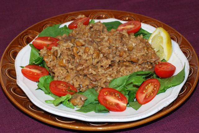 Spiced Lentils and Rice (Mujaddara) served on a bed of spinach with slice grape tomatoes