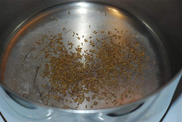 Toasting cumin seeds in a dry pan