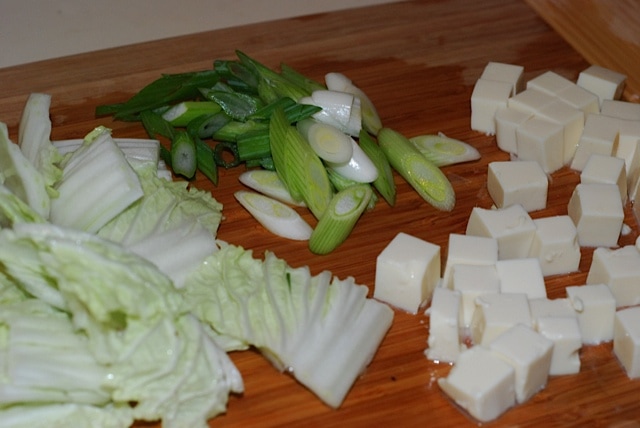 Sliced napa cabbage, tofu cubes, and green onion