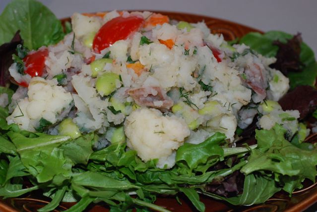 Serve Potato, Cauliflower, Edamame Salad with Yummy Dill Dressing on a bed of greens