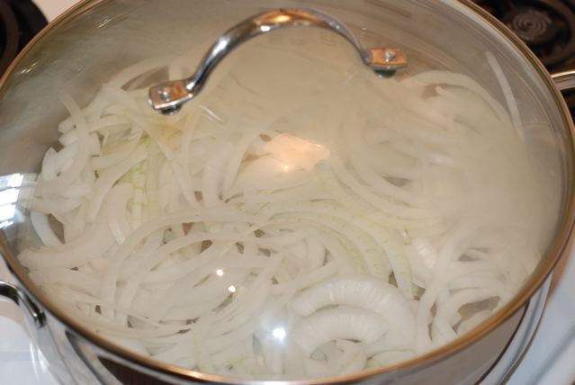 Onions cooking in a pot with a lid