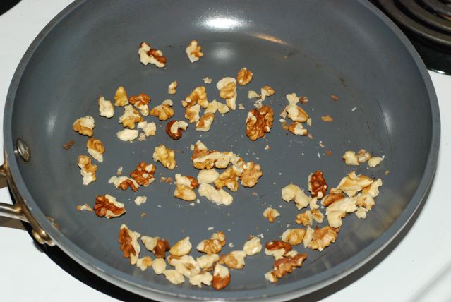 Toasting walnut pieces in a dry frying pan