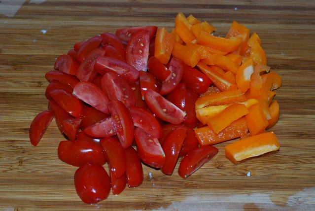 Quartere cherry tomatoes and slice orange pepper