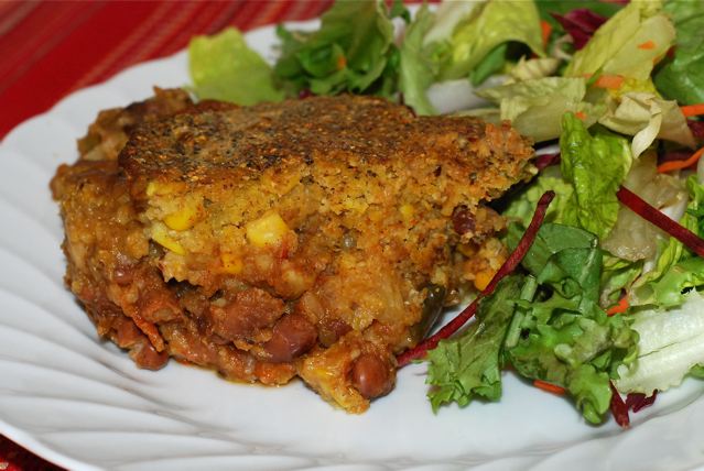 Sweet Potato Chili with Crusty Cornmeal Topping on a plate with a side salad