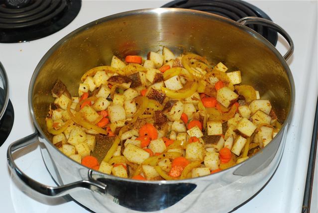 Add potatoes and carrots to the cooked onion and spice mixture