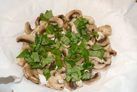 Mushrooms and fresh basil in a parchment-lined pie plate