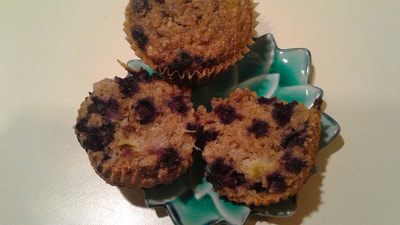 A small plate with 2 warm gluten-free Blueberry Lemon Muffins ready for breakfast or a snack on the go--beansriceeverythingnice@weebly.com